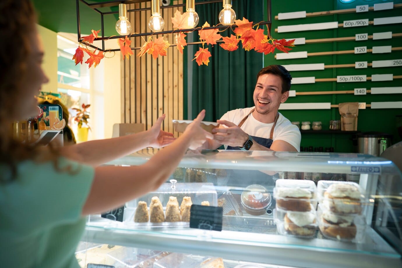 A customer being served across the counter of a bakery.